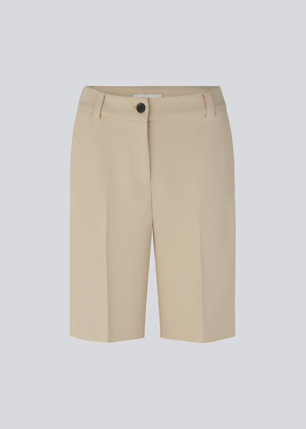 GaleMD shorts i beige har et klassisk design. Shortsene har knælange, vide ben med pressefolder som skaber et elegant look. Modellen er 173 cm og har en størrelse S/36 på.  Style med matchende blazer: Gale blazer, i samme farve.