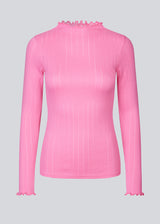 Tætsiddende trøje i pink med mellem høj krave. Issy t-neck har feminine flæsekanter ved hals og ærmer. Kvaliteten er en blød jersey med et feminint pointelle mønster.