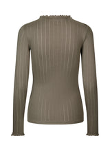 Tætsiddende trøje i brun med mellem høj krave. Issy t-neck har feminine flæsekanter ved hals og ærmer. Kvaliteten er en blød jersey med et feminint pointelle mønster.