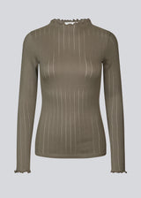 Tætsiddende trøje i brun med mellem høj krave. Issy t-neck har feminine flæsekanter ved hals og ærmer. Kvaliteten er en blød jersey med et feminint pointelle mønster.