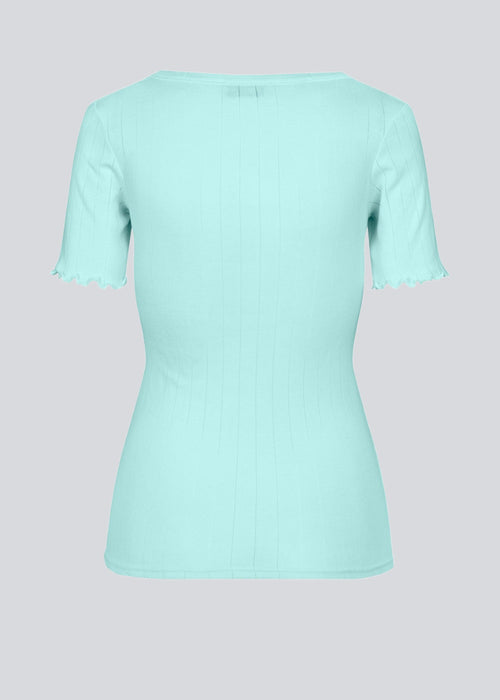 Tætsiddende t-shirt med feminin flæsekant på ærmet. Issy t-shirt er lavet i en blød jersey med et enkelt hulmønster. Modellen er 174 cm og har en størrelse S/36 på  Materiale: 50% Modal 50% Bomuld