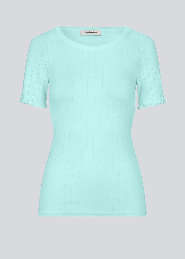 Tætsiddende t-shirt med feminin flæsekant på ærmet. Issy t-shirt er lavet i en blød jersey med et enkelt hulmønster. Modellen er 174 cm og har en størrelse S/36 på  Materiale: 50% Modal 50% Bomuld
