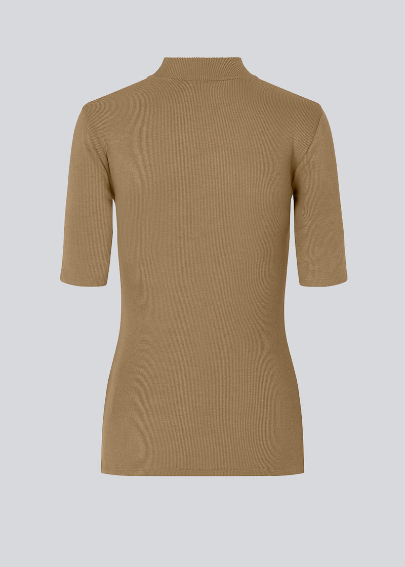 Kortærmet t-shirt i brun med høj hals. Krown t-shirt er i rib kvalitet og er tætsiddende i pasformen. T-shirten er i en lækker Eco Vero Viskose kvalitet.