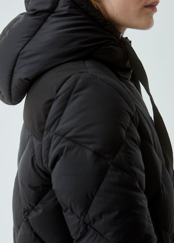 Skøn dunjakke i diamantquilt i sort. Jakken har en hætte med justerbare snore og to lynlås-lukkede lommer. Kyra coat har et fyld bestående af dun, som giver en fantastisk isolering mod kulden på selv de koldeste dage. Holder dig varm ned til -15 grader. Den er vand- og vindafvisende.