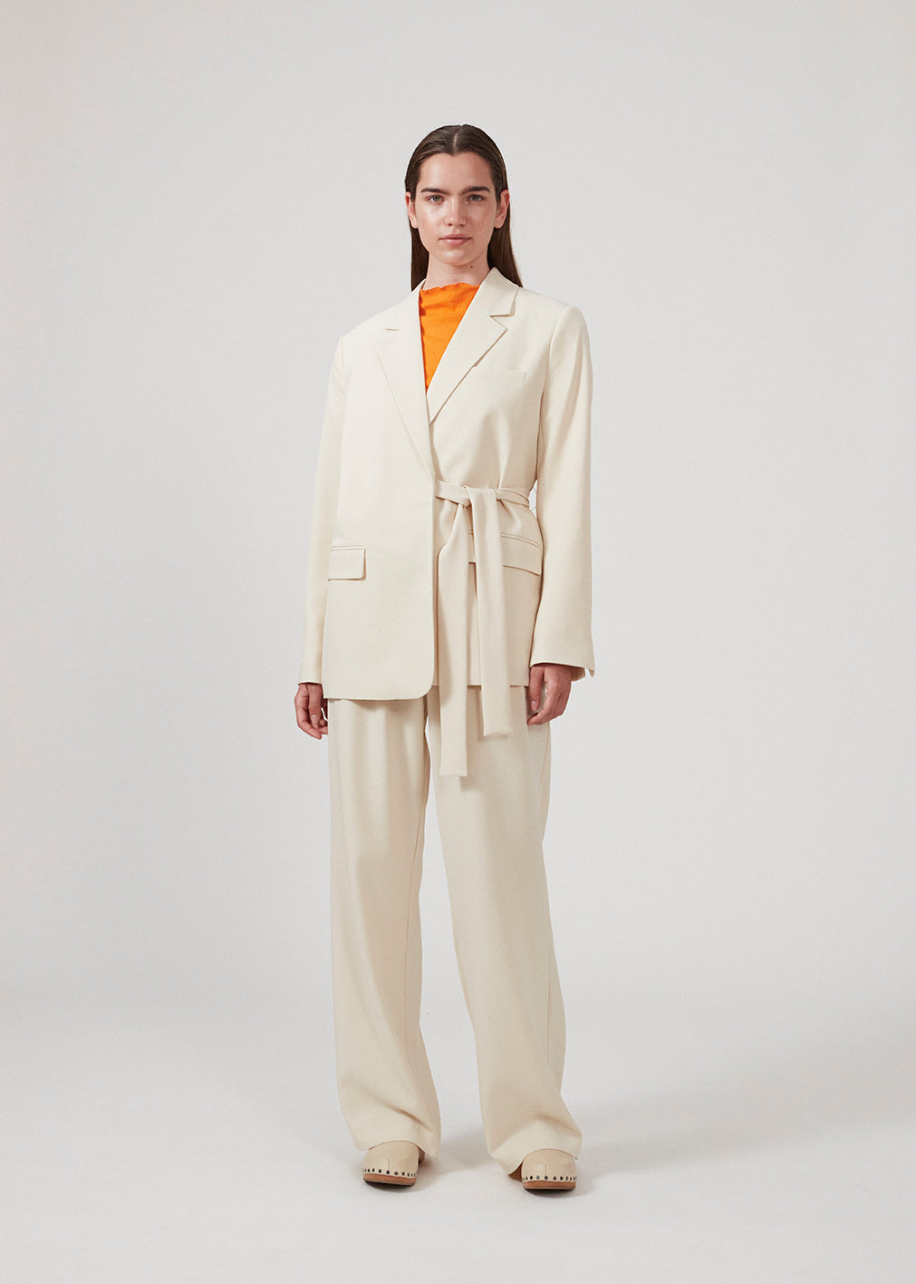 Løse bukser i beige med brede ben, der er fremstillet af genanvendte materialer. Dobbelte plisseringer foran, lynlåsgylp og knaplukning. Modellen er 177 cm og har en størrelse S/36 på.  Style med den matchende blazer: CayaMD blazer.