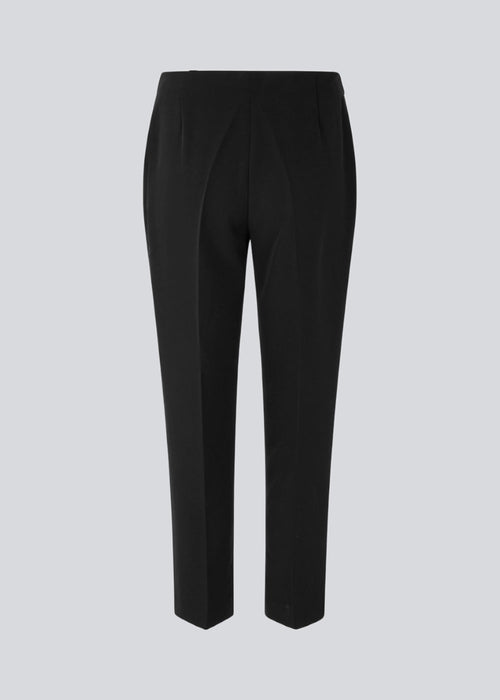 Klassiske bukser i sort med pressefolder og lige afkortede ben. NelliMD cropped pants lukkes med en skjult lynlås i siden og har en skjult elastik i taljen for et mere komfortabelt fit. Modellen er 173 cm og har en størrelse S/36 på