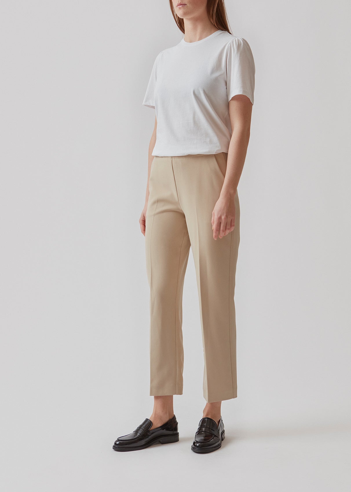 Klassiske bukser i beige med pressefolder og lige afkortede ben. NelliMD cropped pants lukkes med en skjult lynlås i siden og har en skjult elastik i taljen for et mere komfortabelt fit. Modellen er 173 cm og har en størrelse S/36 på