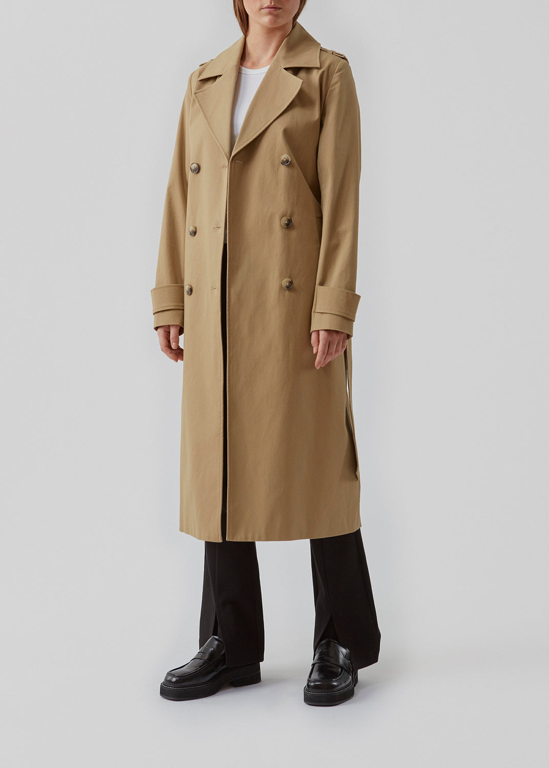 Klassisk trenchcoat i en tyk bomuldskvalitet. Oak jacket er dobbeltradet, med revers og slids bagpå. Det brede bindebælte og manchetter tilføjer de sidste detaljer til den velkendte silhuet. Modellen er 173 cm og har en størrelse S/36 på