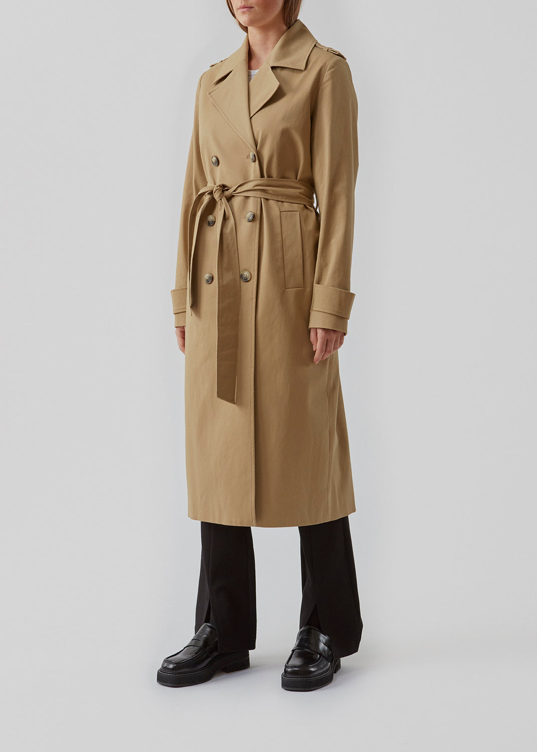 Klassisk trenchcoat i en tyk bomuldskvalitet. Oak jacket er dobbeltradet, med revers og slids bagpå. Det brede bindebælte og manchetter tilføjer de sidste detaljer til den velkendte silhuet. Modellen er 173 cm og har en størrelse S/36 på