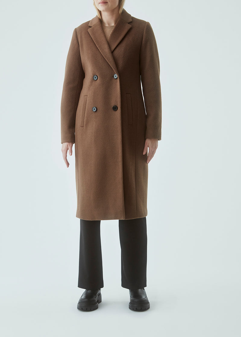 Smuk, lang uldfrakke. Odelia long coat er dobbeltradet og taljeret, hvilket giver et feminint udtryk. Frakken er et oplagt valg til både efterår og de milde vintre.