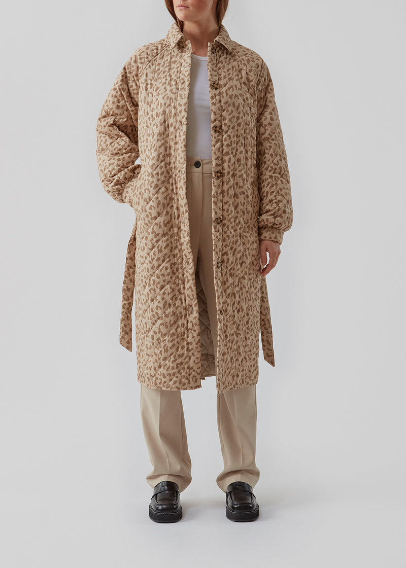 Denne lange, quiltede jakke holder dig varm og smart på samme tid. Olise print jacket har et blødt og feminint udtryk med ballonærmer og et bindebælte i taljen. Her i leopard print. Modellen er 173 cm og har en størrelse S/36 på