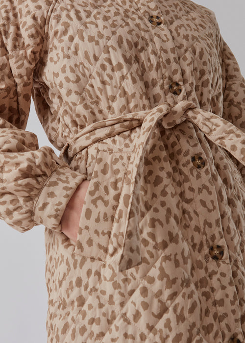 Denne lange, quiltede jakke holder dig varm og smart på samme tid. Olise print jacket har et blødt og feminint udtryk med ballonærmer og et bindebælte i taljen. Her i leopard print. Modellen er 173 cm og har en størrelse S/36 på