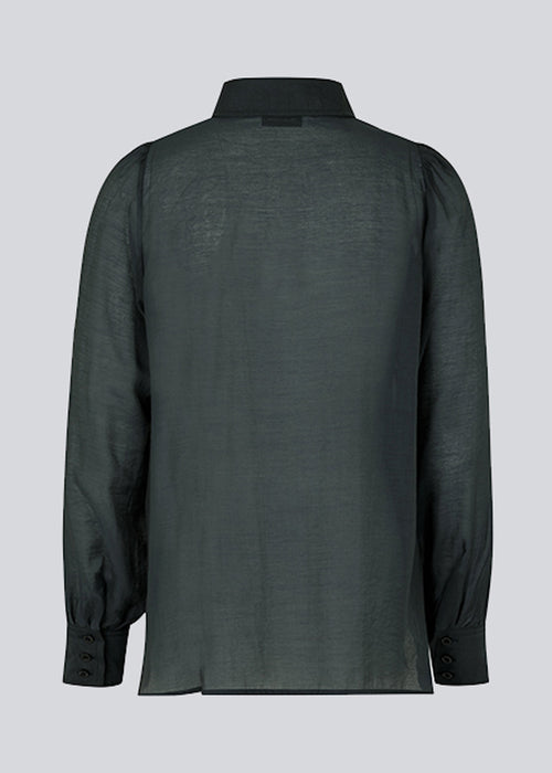 Klassisk skjorte i mørkeblå i et let og luftigt materiale. Oskar shirt har en afslappet pasform med voluminøse ballonærmer der afsluttes med en bred manchet. Skjorten er en smule gennemsigtig som skaber et ultra feminint udtryk. Modellen er 174 cm og har en størrelse S/36 på.