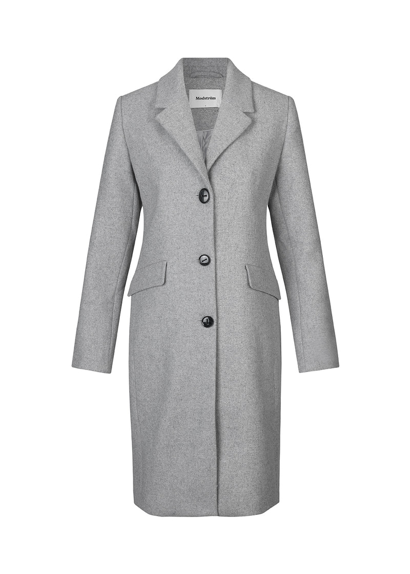 Smuk knælang uldfrakke i grå. Pamela coat bliver knappet fortil af 3 store knapper og er taljeret, som giver et feminint udtryk. På grund af den høje kvalitet af uld, vil den være det oplagte valg at bruge til både efterår og de milde vintre.