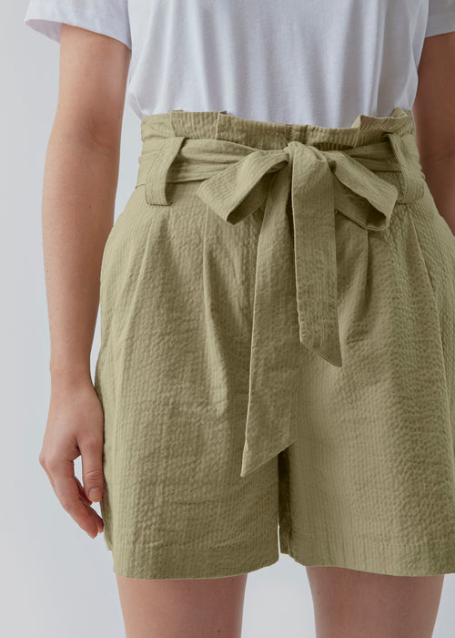 Panne shorts er fremstillet i en struktureret bomuldskvalitet. Disse shorts har en afslappet, højtaljet silhuet dekoreret med bindebånd i taljen. Modellen er 173 cm og har en størrelse S/36 på