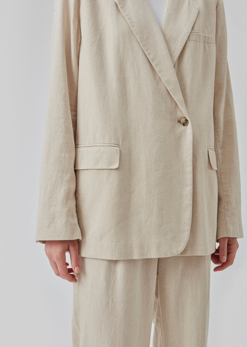 Blazer i et voluminøst fit med et asymmetrisk look. Park blazer er i en let hørkvalitet, som kan styles med de matchende bukser eller over en kjole på en sommeraften.  Materiale: 45% Bomuld 55% Linen  Foer: 100% Polyester