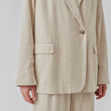 Blazer i et voluminøst fit med et asymmetrisk look. Park blazer er i en let hørkvalitet, som kan styles med de matchende bukser eller over en kjole på en sommeraften.  Materiale: 45% Bomuld 55% Linen  Foer: 100% Polyester