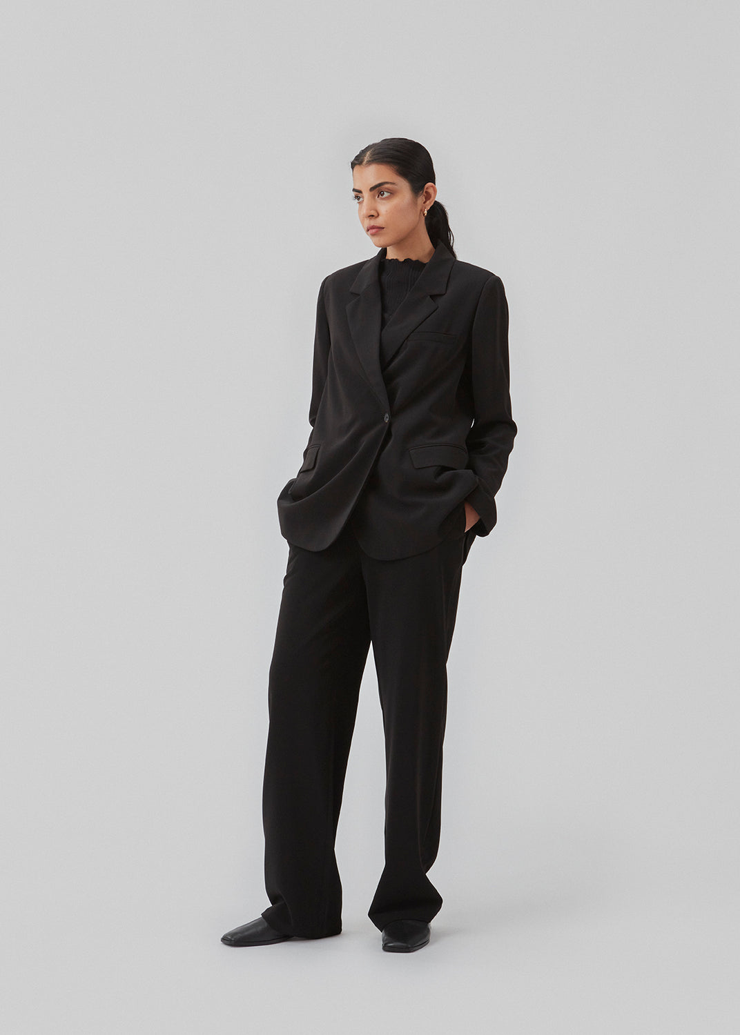 Sort blazer i et oversize fit med et asymmetrisk look. PerryMD blazer er i en let kvalitet, som kan styles med de matchende bukser eller over en kjole på en sommeraften. Indersøm (S/36): 81 cm Bukserne forlænges med 0,5 cm for hver størrelse. Modellen er 173 cm og har en størrelse S/36 på.  Shop matchende bukser, for at fuldende looket: PerryMD pants.