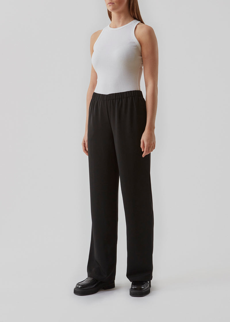 Bukser i mørkebrun i et simpelt design med brede ben. Perry pants har skrålommer i siden og en elastisk talje for et behageligt fit. Indersøm (S/36): 81 cm Bukserne forlænges med 0,5 cm for hver størrelse. Modellen har bukserne på i sort og er 173 cm og har en størrelse S/36 på