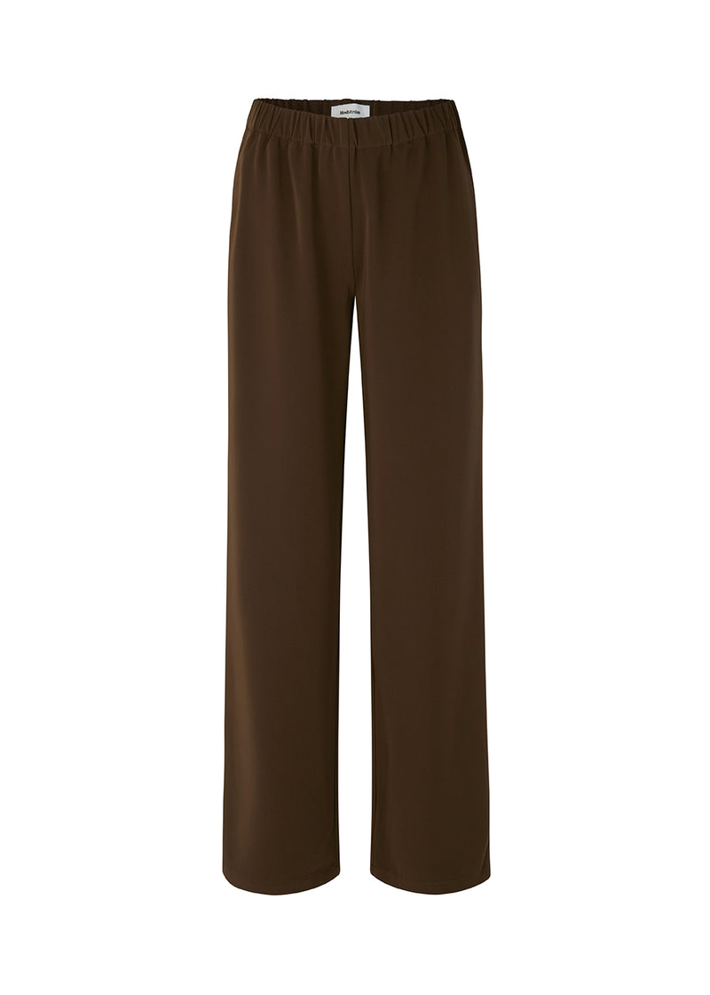 Bukser i mørkebrun i et simpelt design med brede ben. Perry pants har skrålommer i siden og en elastisk talje for et behageligt fit. Indersøm (S/36): 81 cm Bukserne forlænges med 0,5 cm for hver størrelse. Modellen har bukserne på i sort og er 173 cm og har en størrelse S/36 på