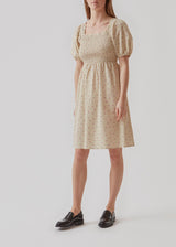 Mellemlang kjole med firkantet udskæring med lille flæsekant. ReeceMD print dress har korte pufærmer, samt smock over brystet for en kropsnær pasform foroven. Modellen er 173 cm og har en størrelse S/36 på
