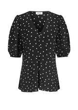 Bluse i en mere ansvarlig kvalitet i sort med prikker. RidderMD print top har korte pufærmer og v-udskæring. Den voluminøse pasform detaljeres med et wienerlæg foran. Modellen er 173 cm og har en størrelse S/36 på.