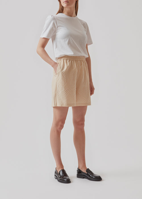 Afslappede shorts i beige i en struktureret ternet kvalitet. RimmeMD shorts har elastisk talje, sidelommer og en dekorativ paspoleret baglomme. Modellen er 173 cm og har en størrelse S/36 på