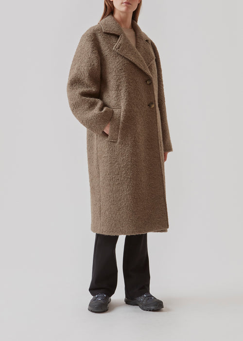 Frakke i blød uldkvalitet i brun med afslappet pasform og lange, voluminøse ærmer. SallieMD coat er mellemlang med krave og revers samt knaplukning fortil. Sidelommer og slids bagpå. Med for