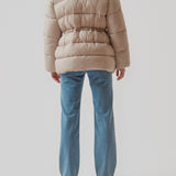Polstret jakke i beige med oversize pasform and justerbar talje. StellaMD jacket har opretstående krave, hætte, tovejslynlås og to paspolerede forlommer.