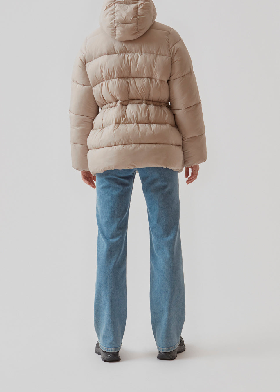 Polstret jakke i beige med oversize pasform and justerbar talje. StellaMD jacket har opretstående krave, hætte, tovejslynlås og to paspolerede forlommer.