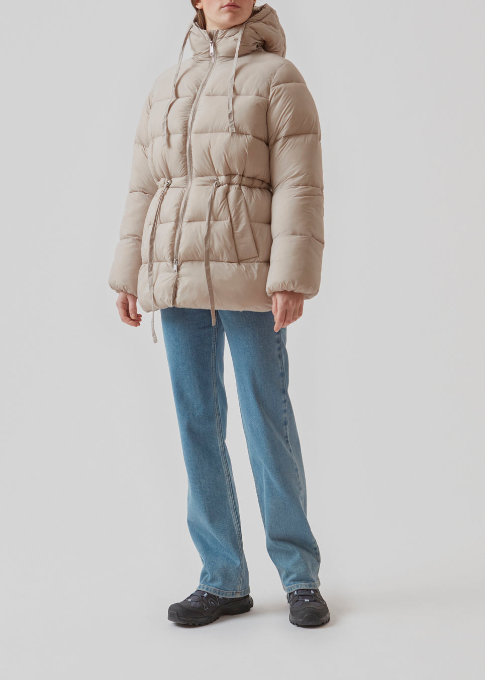Polstret jakke i beige med oversize pasform and justerbar talje. StellaMD jacket har opretstående krave, hætte, tovejslynlås og to paspolerede forlommer.