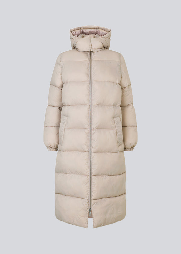 Knælang frakke i vatteret nylon. StellaMD long jacket har en afslappet pasform med lange ærmer, hætte og opretstående krave. Tovejslynlås, justerbar hætte og diskrete sidelommer.