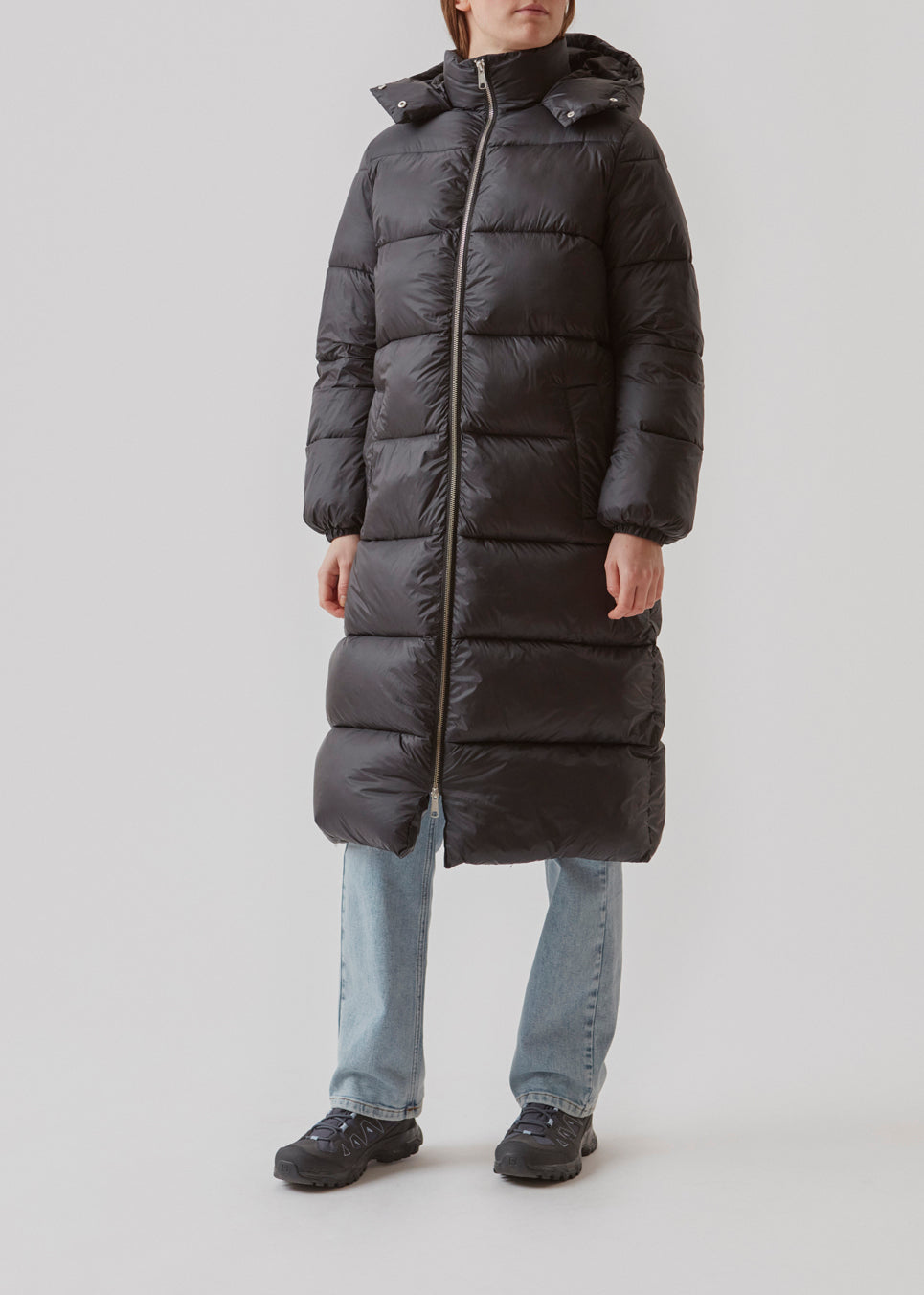 Knælang fakke i sort i vatteret nylon. StellaMD long jacket har en afslappet pasform med lange ærmer, hætte og opretstående krave. Tovejslynlås, justerbar hætte og diskrete sidelommer.