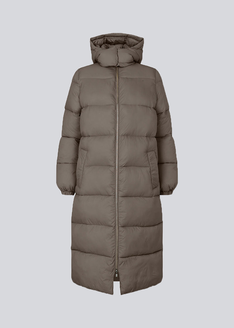 Knælang frakke i vatteret nylon. StellaMD long jacket har en afslappet pasform med lange ærmer, hætte og opretstående krave. Tovejslynlås, justerbar hætte og diskrete sidelommer.
