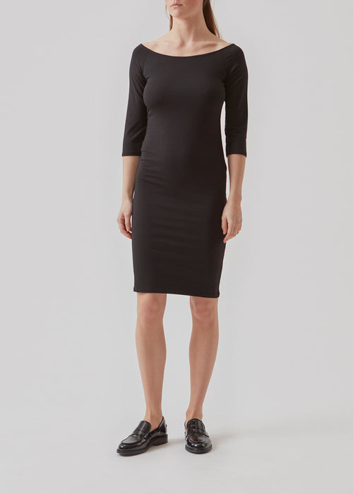Kjolen har et enkelt look med en bred udskæring både for og bag og smalle ærmer. Tansy dress i farven sort er en small model, der sidder tæt til uden at være stram.