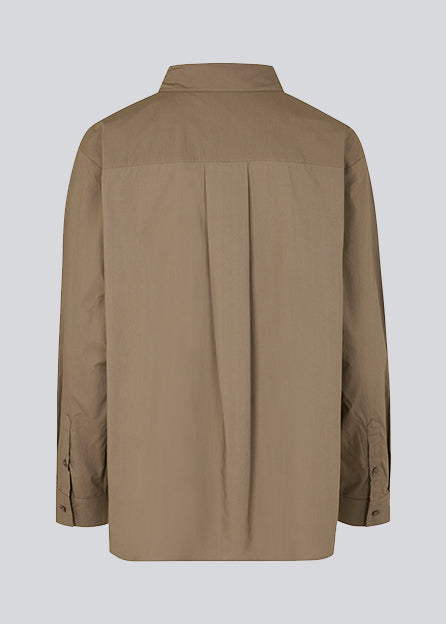 Luftig skjorte i farven Spring stone i økologisk bomuldspoplin. TapirMD shirt har krave og knapper foran, samt åben brystlomme. Lav skuldersøm og lange ærmer med manchet og knap. Broderet logo foran.  Modellen er 177 cm og har en størrelse S/36 på.