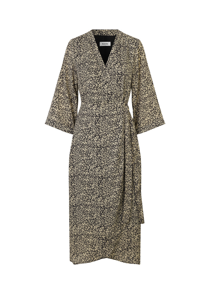 Theodora print dress er en klassisk slå om-kjole med bindebånd i taljen, og en længde der er en smule kortere foran. Kjolen har v-udskæring og brede, 3/4 længde ærmer.