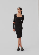 Tætsiddende kjole i sort i en ribstrikket bomuldskvalitet. ToxieMD dress har firkantet udskæring foran og lange ærmer. Modellen er 177 cm og har en størrelse S/36 på.