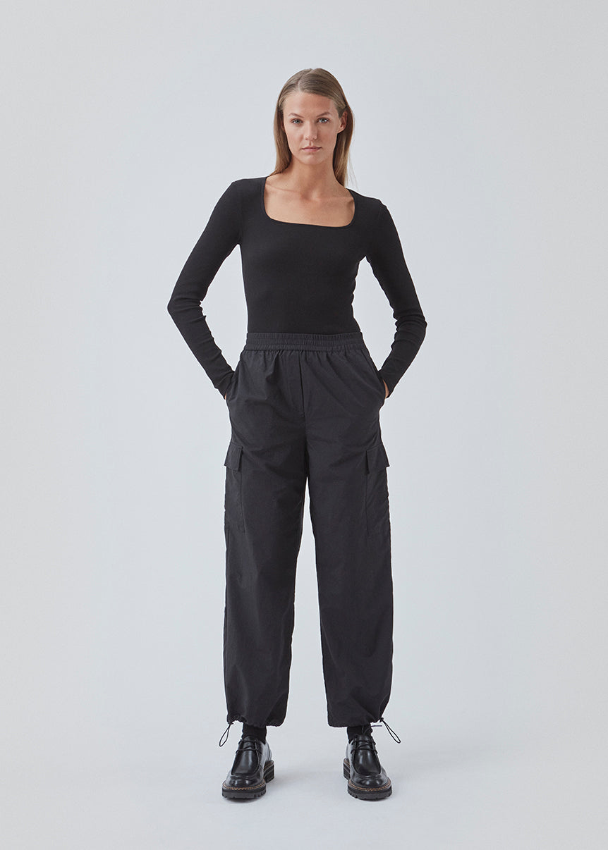Cargobukser i nylon med elastisk talje og justerbare kanter med løbesnor. TrentMD pants har påsyede lommer på benene. Farven er sort.  TrentMD pants er lavet på samme model som vores meget populære og udsolgte AmayaMD pants. Dog i en kraftigere kvalitet, perfekt til efterår og vinter. 