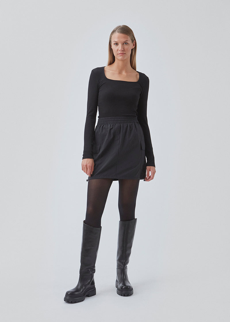 Kort nederdel i nylon med elastik i taljen og justerbar kant med løbesnor. TrentMD skirt har to påsyede lommer og vertikale skæringer på front og bag.