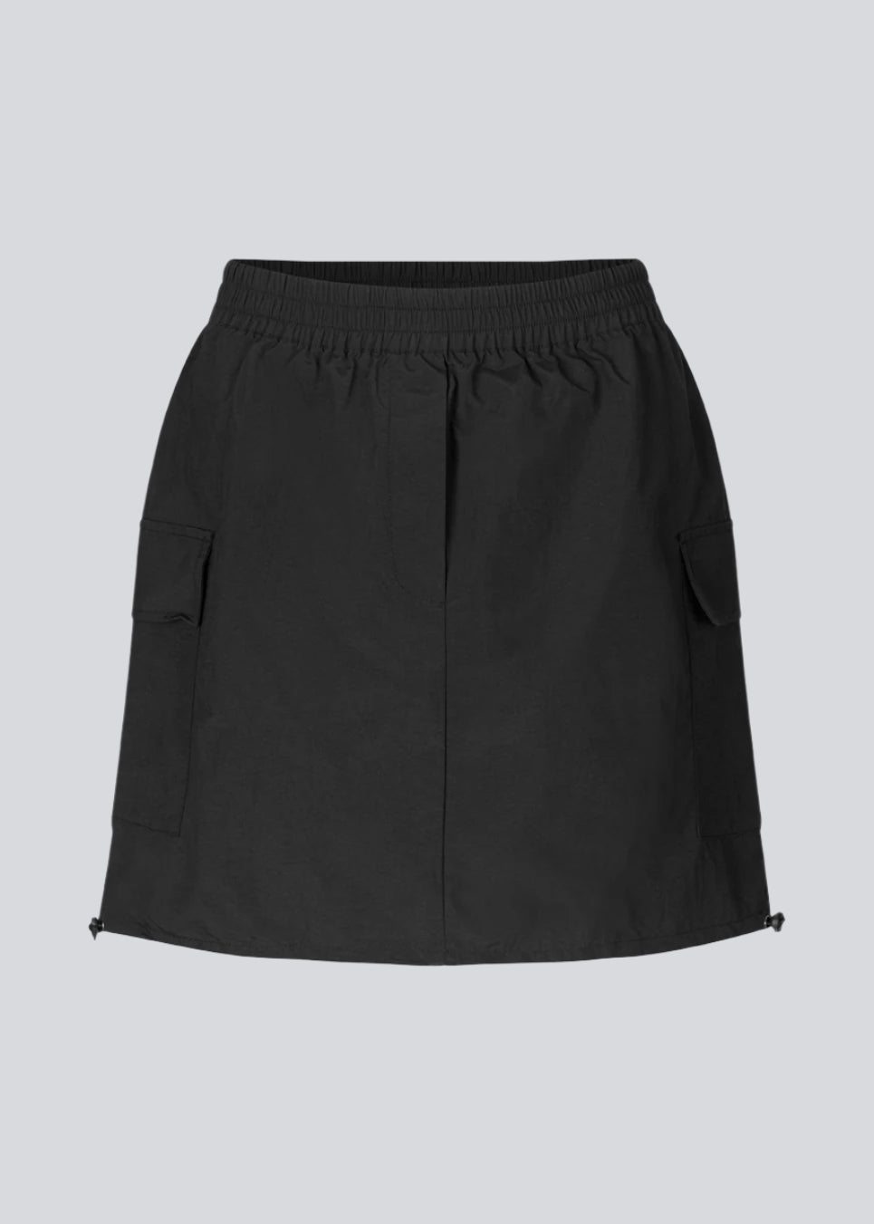 Kort nederdel i nylon med elastik i taljen og justerbar kant med løbesnor. TrentMD skirt har to påsyede lommer og vertikale skæringer på front og bag.